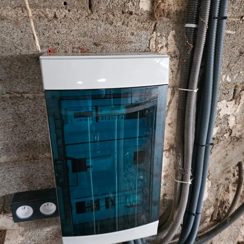Armoire électrique neuve fixée sur un mur en parpaing dans un ranch à Palau-del-Vidre