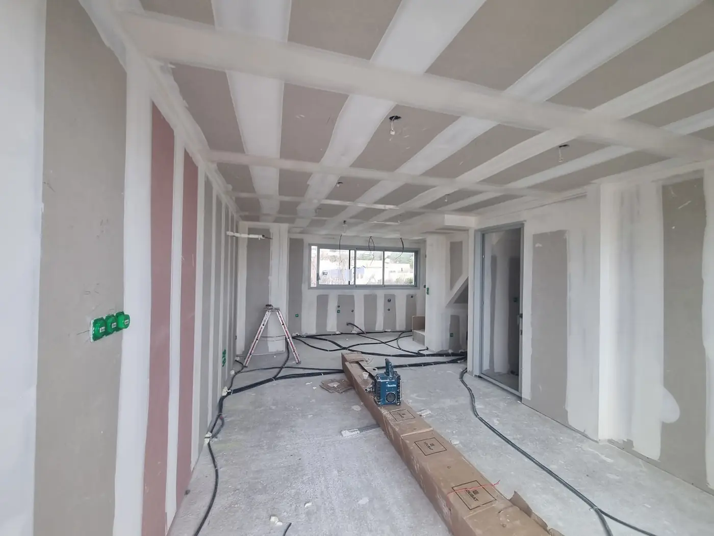 Plateau en travaux avec câbles au sol et plafond en plaques de plâtre à Argelès-sur-Mer