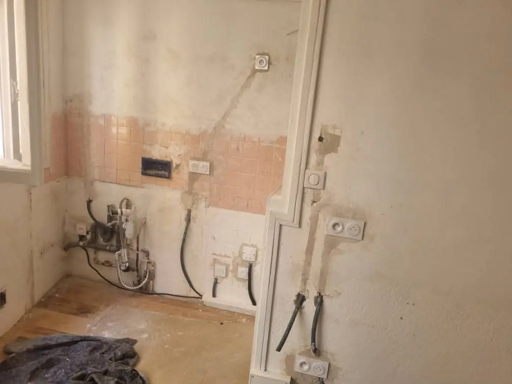 Gaines électriques encastrées dans le mur en béton d’une cuisine à Collioure