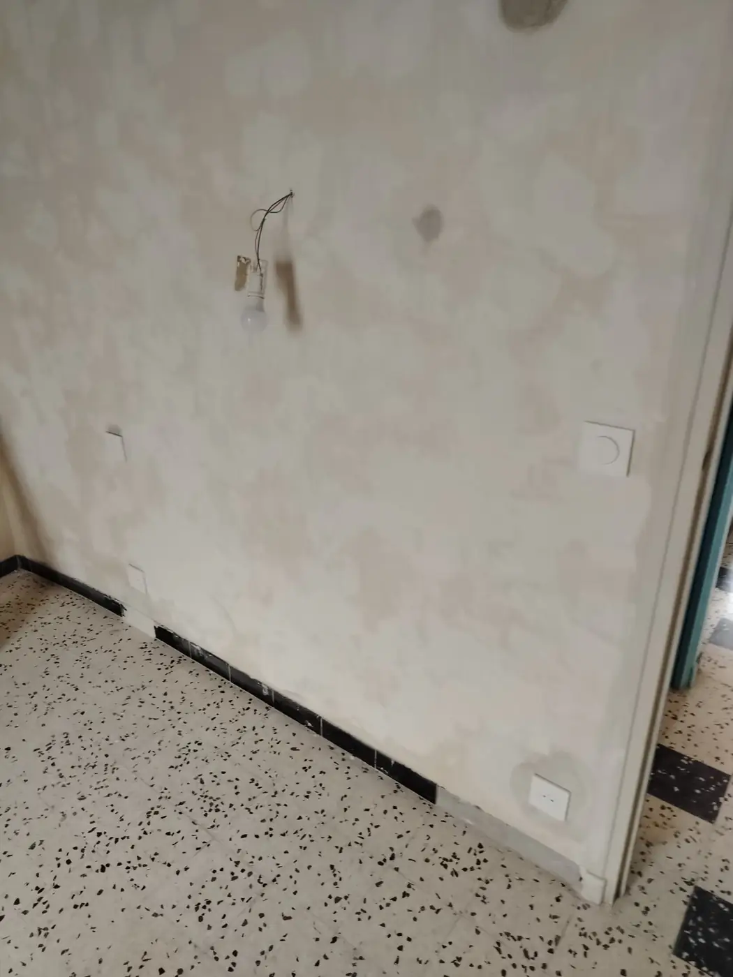 Interrupteur et sortie de câble posés sur un mur rebouché au Boulou