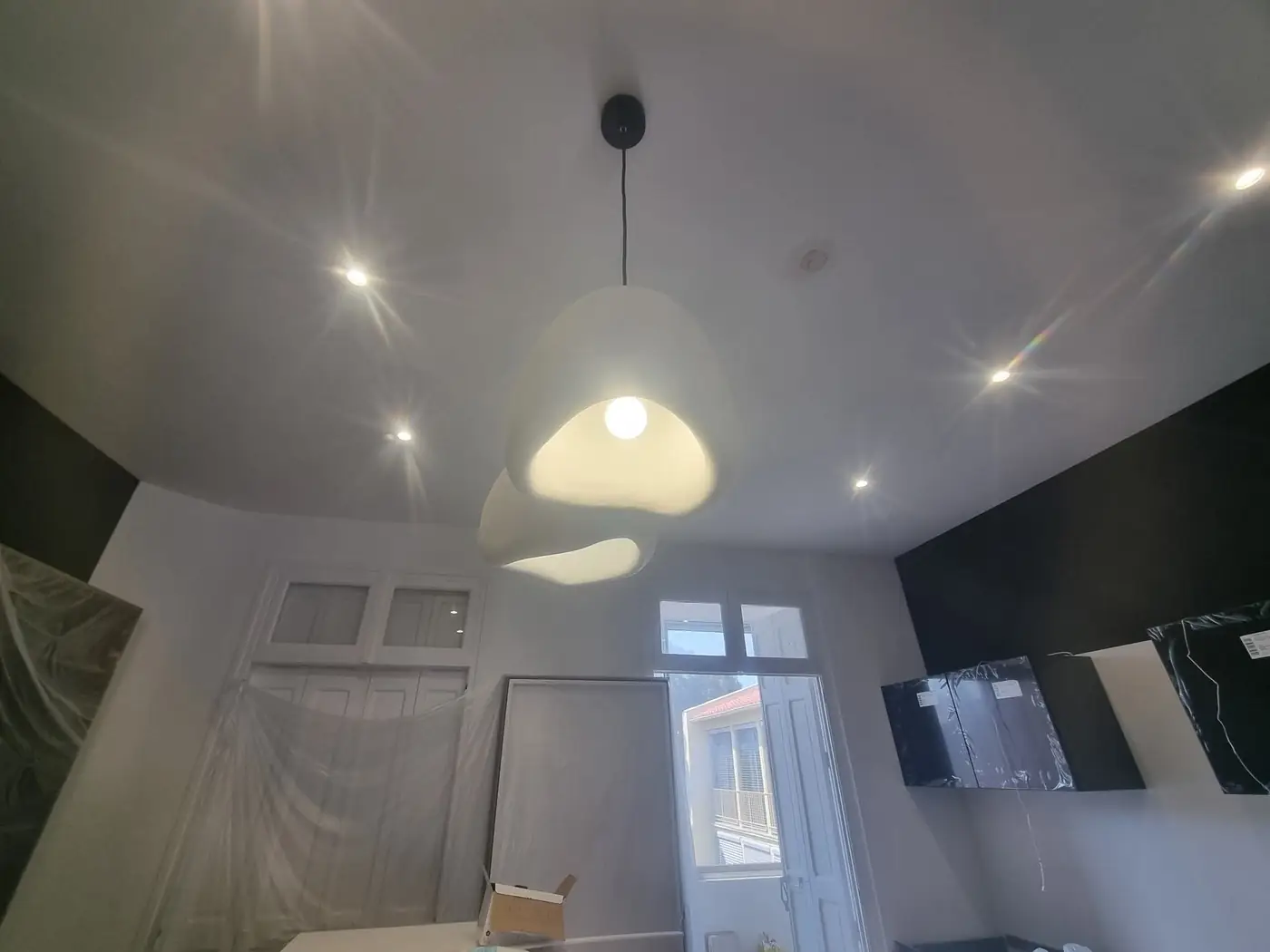 Luminaire en forme d’œuf et spots au plafond d’un séjour rénové à Perpignan