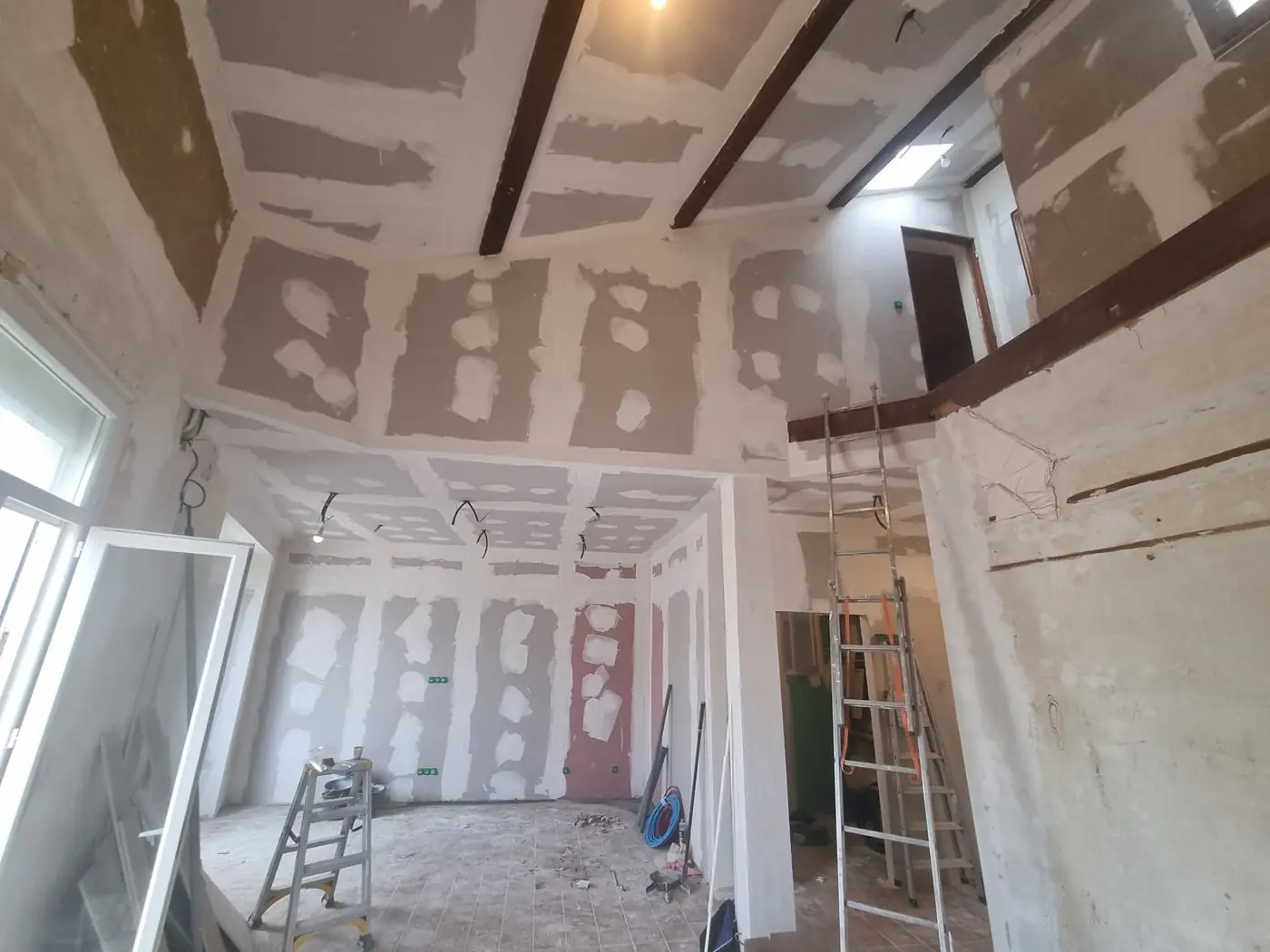 Pièce à poutres et mezzanine pendant la rénovation électrique à Perpignan