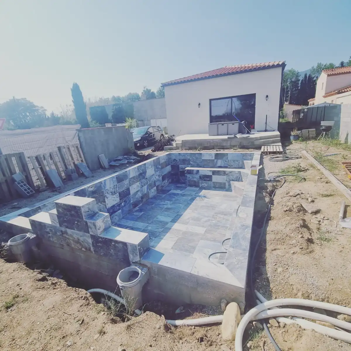 Piscine en construction devant une maison