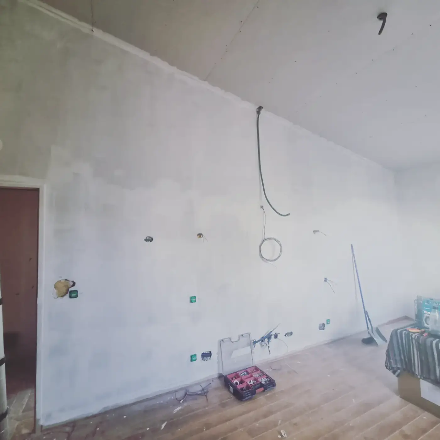 Mur en rénovation avec prises et sorties de câbles posées avant la peinture