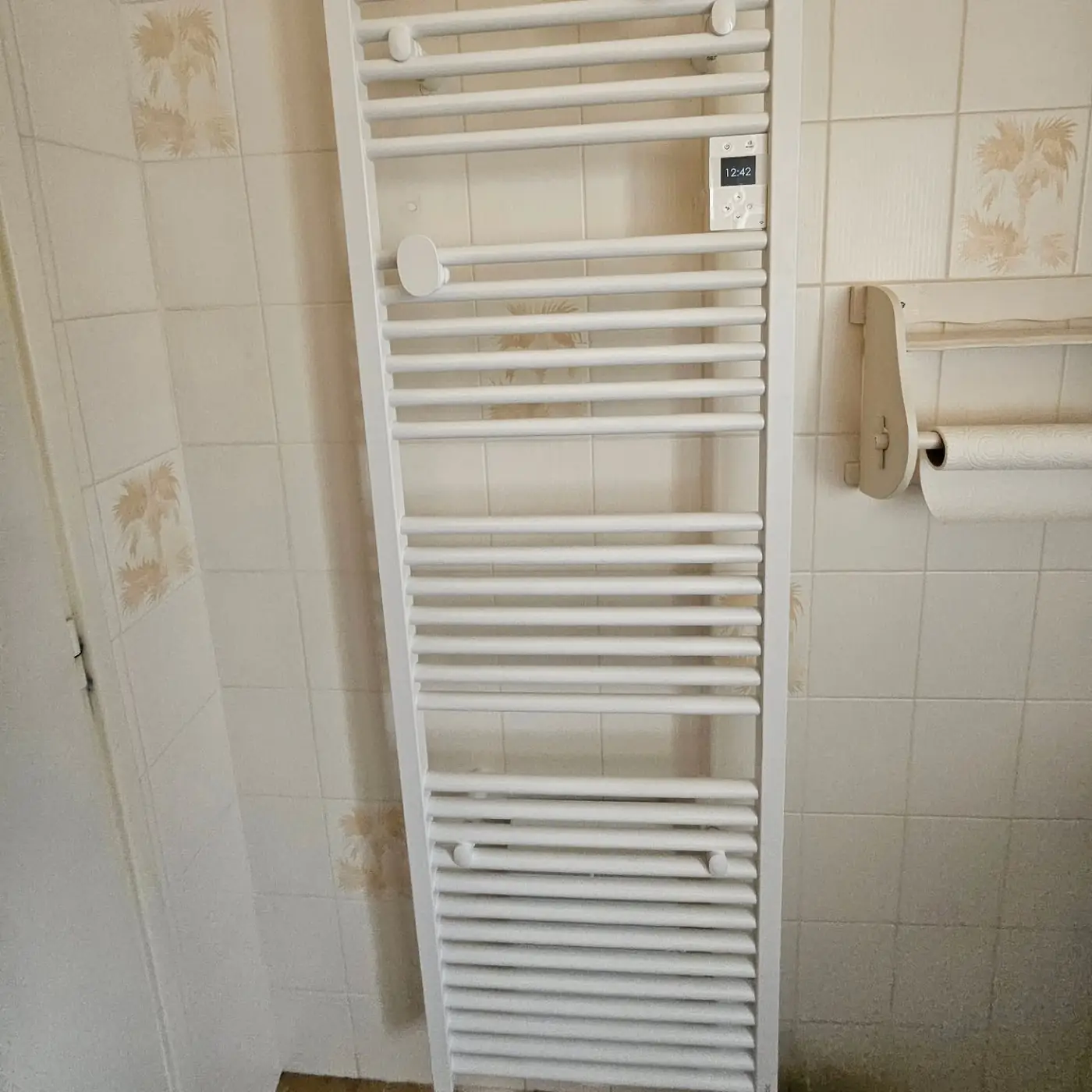Radiateur sèche-serviettes électrique Atlantic posé dans une salle de bains carrelée